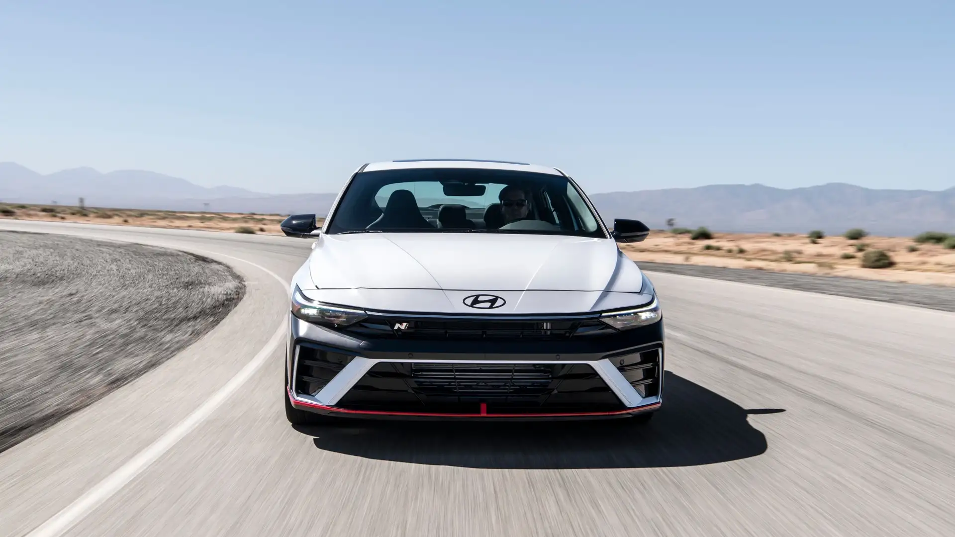 2026 Hyundai Elantra N sports sedan cornering on a racetrack featuring aggressive styling and high performance.