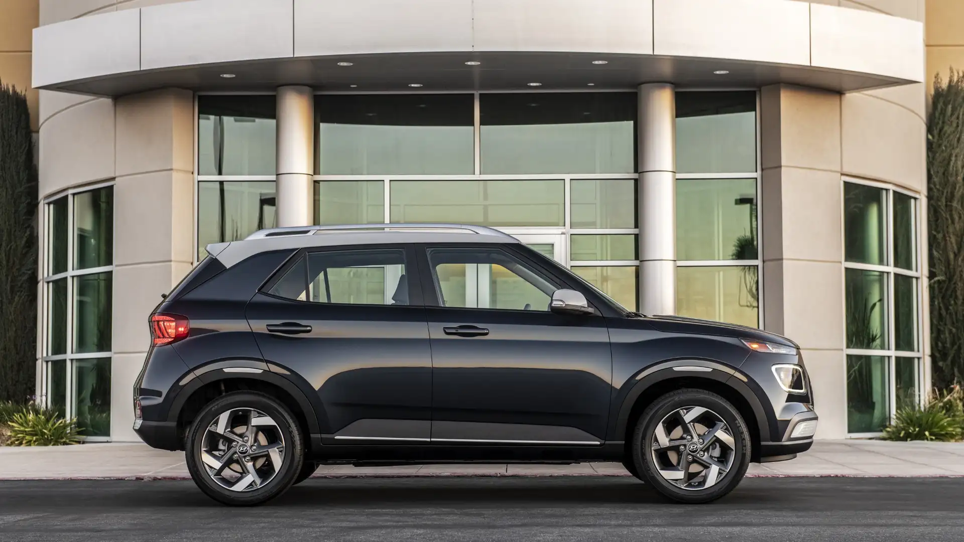 2026 Hyundai Venue compact SUV parked in front of a modern building showcasing urban design and versatility.