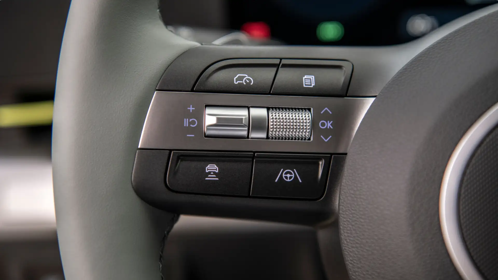 2025 Hyundai Kona Electric steering wheel controls with illuminated cruise and lane assist buttons in close-up view.