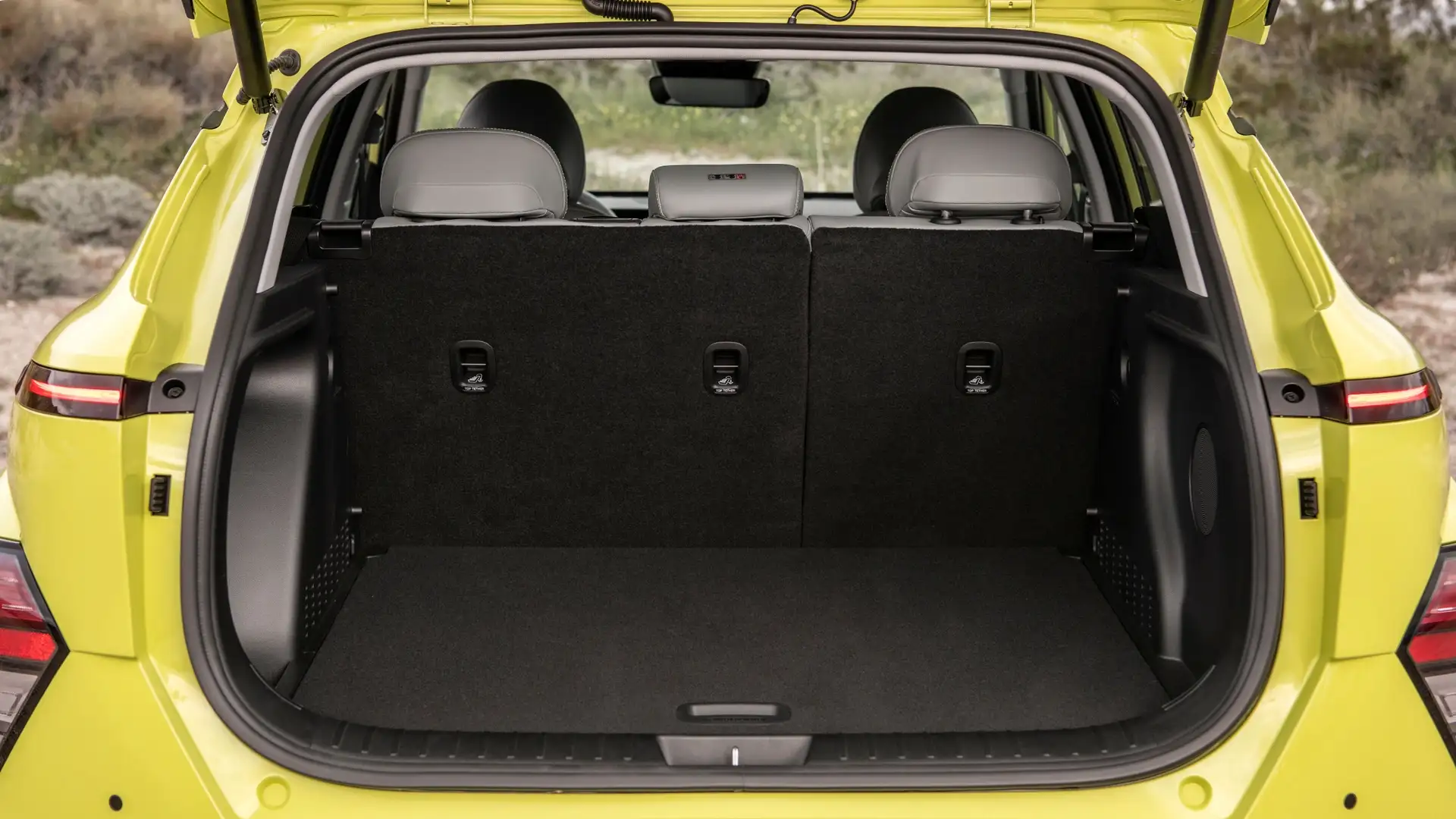 2025 Hyundai Kona Electric rear cargo area with upright second-row seats and wide tailgate opening.