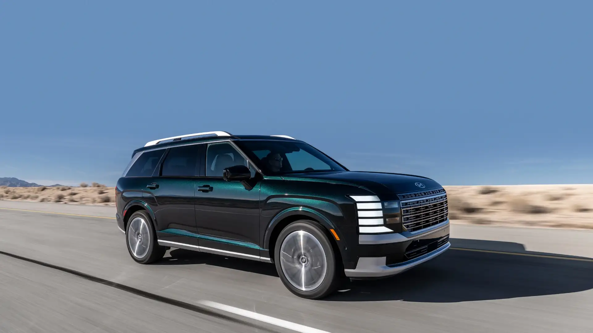 2026 Hyundai Palisade cruising on open highway with deep green finish and upscale modern silhouette.