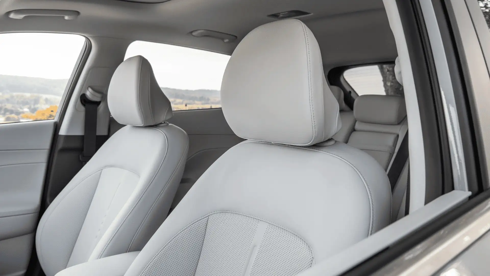 2026 Hyundai Kona interior seating view with light gray upholstery, front and rear seats, and spacious cabin layout.