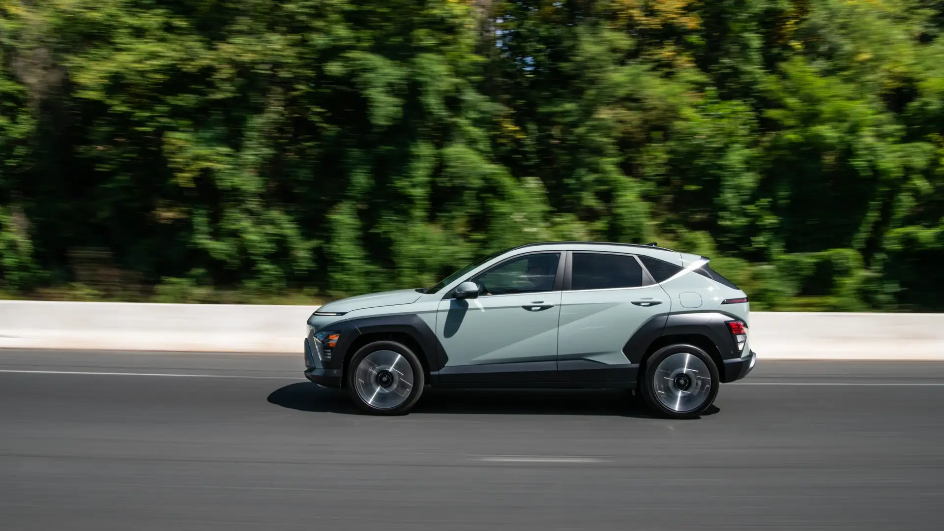 2026 Hyundai Kona compact SUV side profile driving view in light green.