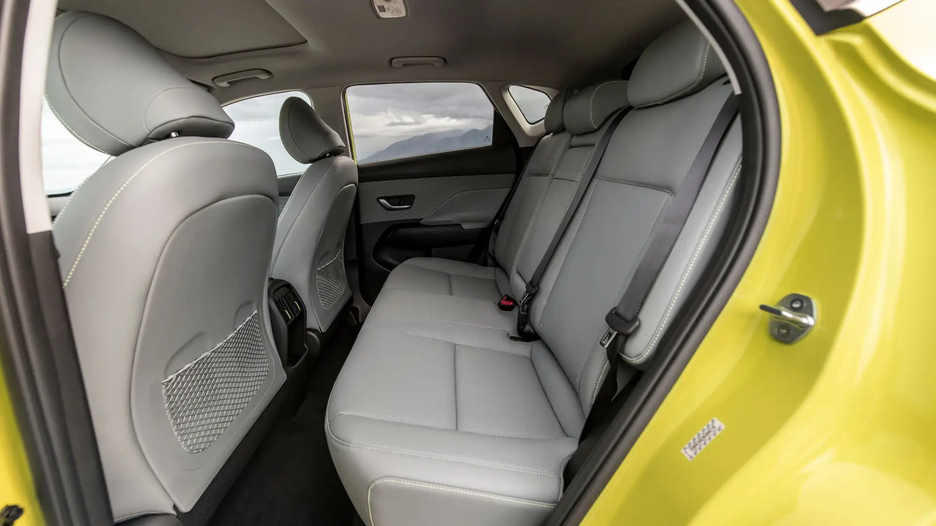 2026 Hyundai Kona Electric rear interior with gray upholstery, spacious legroom, and comfortable second-row seating.