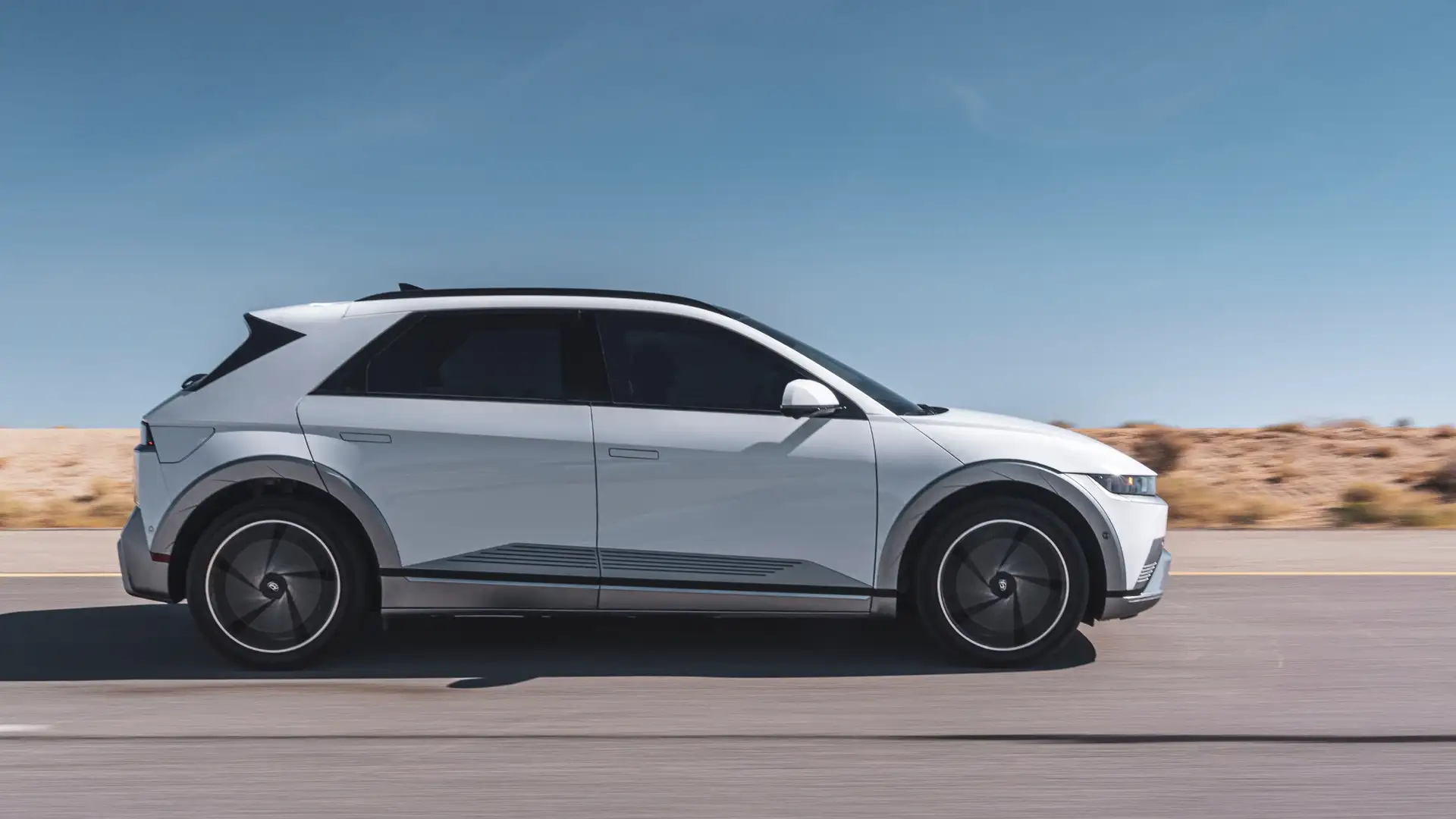 2026 Hyundai IONIQ 5 electric SUV exterior side view driving on road with aerodynamic design.