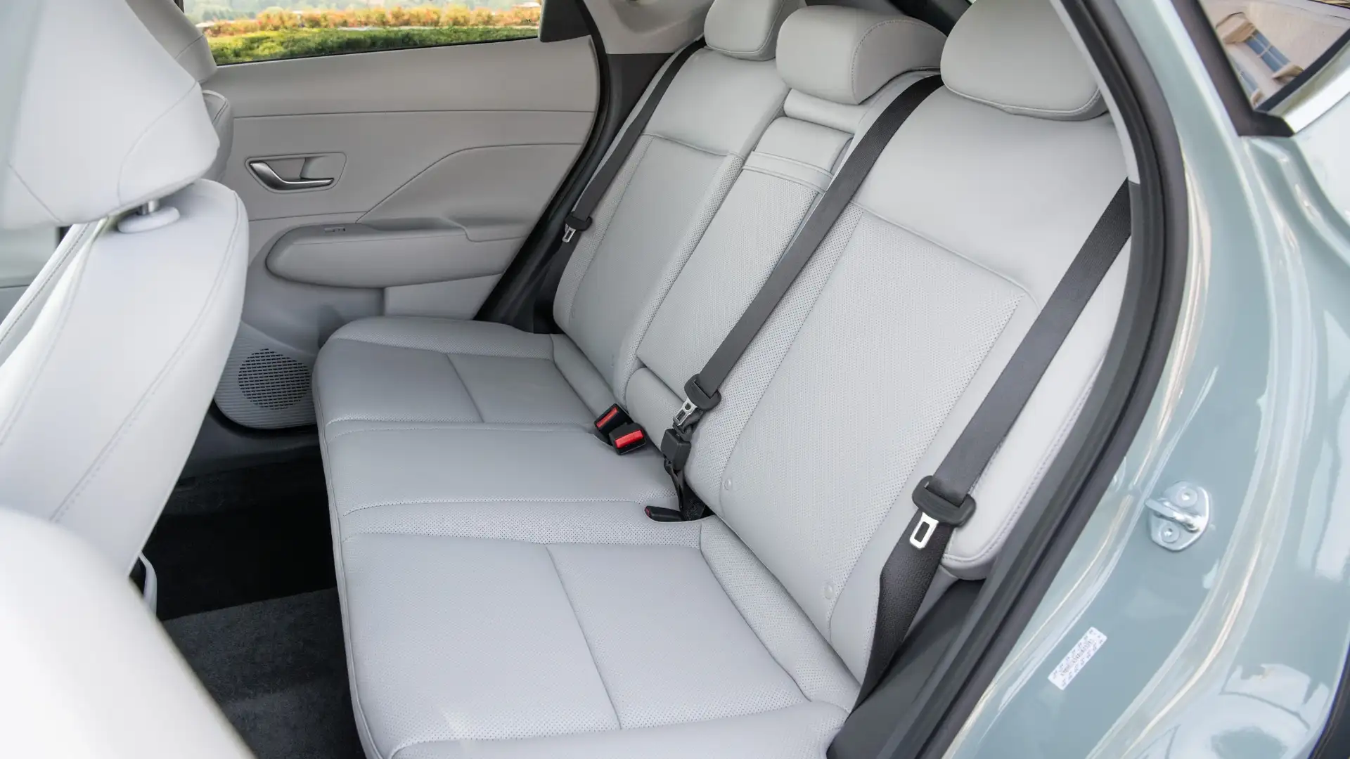 2026 Hyundai Kona rear seat interior showing spacious seating, light upholstery, seatbelts, and rear passenger comfort.