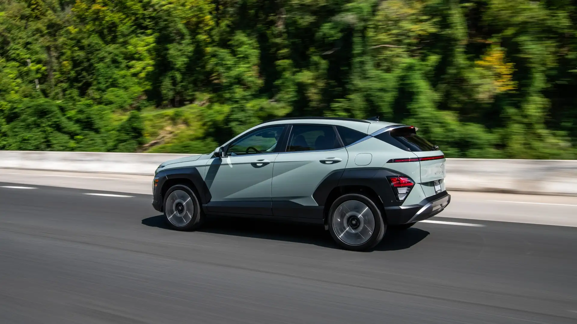 2026 Hyundai Kona exterior driving on highway with updated design, alloy wheels, and compact SUV styling.