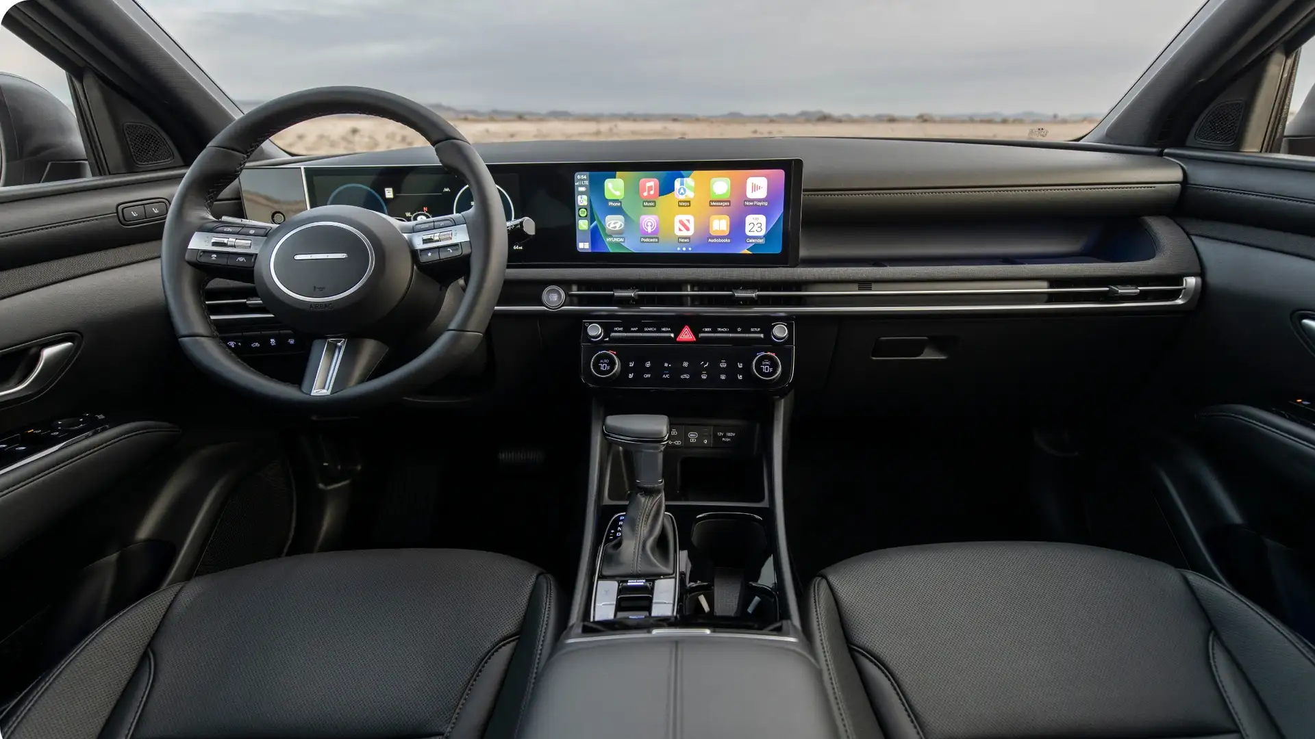 2026 Hyundai Santa Cruz interior showing dashboard layout, center touchscreen, gear selector, and front seating area..