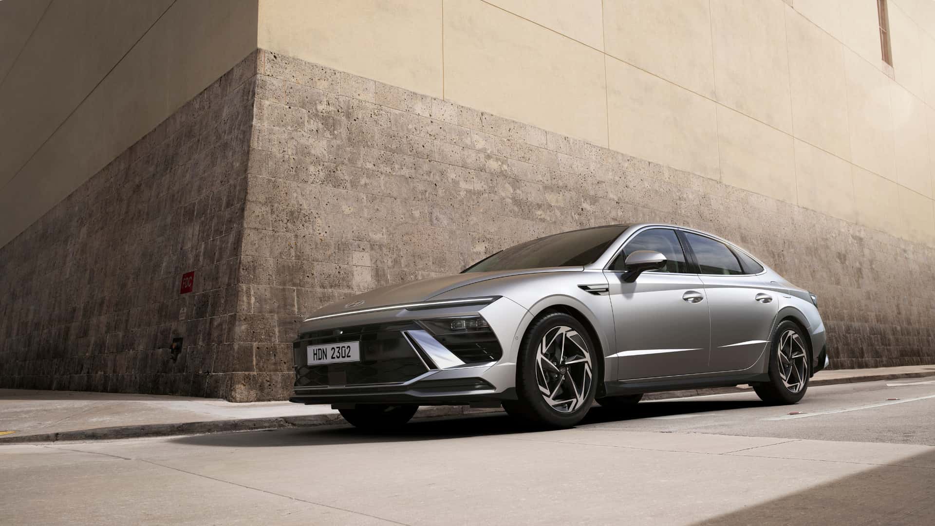 2026 Hyundai Sonata sedan parked in an open-air concrete structure, front three-quarter view with sleek LED lighting.
