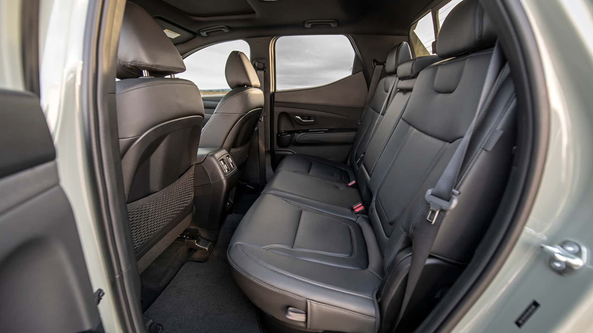 2026 Hyundai Santa Cruz rear seating area with black upholstery and rear passenger space.