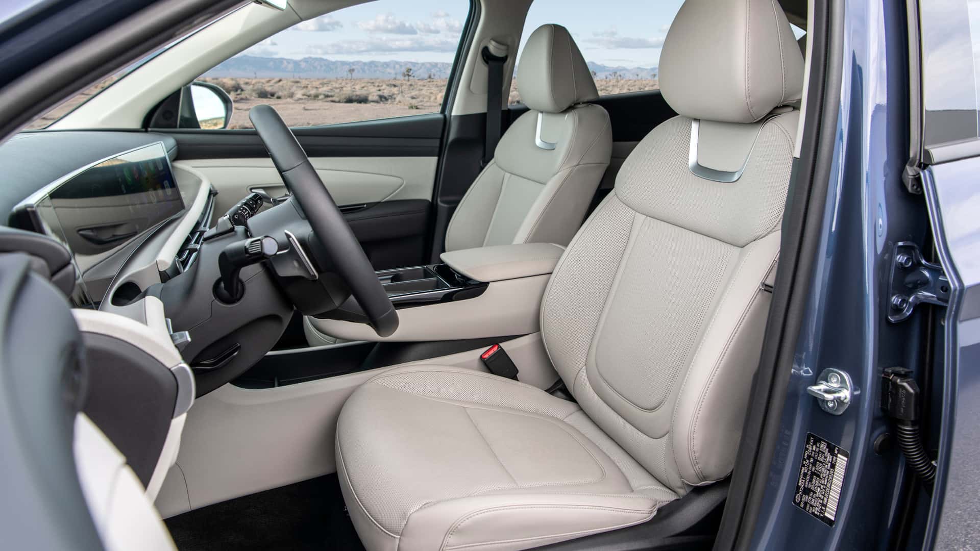 2026 Hyundai Tucson front seats with light upholstery and center armrest detail.