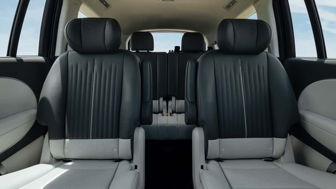 2026 Hyundai IONIQ 9 interior rear view highlighting black and gray seats, spacious cabin, and second-row seating arrangement.