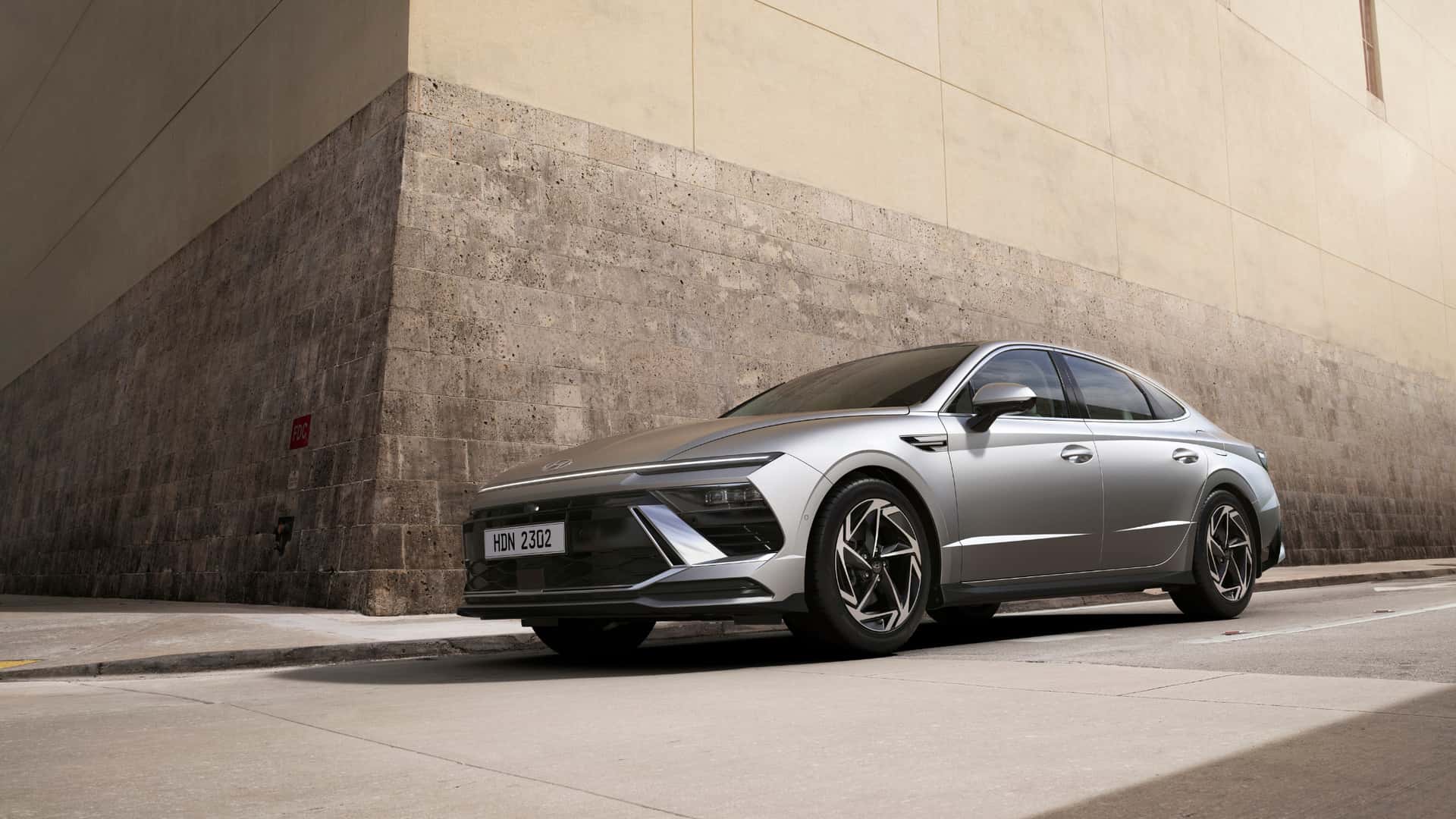 2026 Hyundai Sonata sedan parked beside urban concrete building.