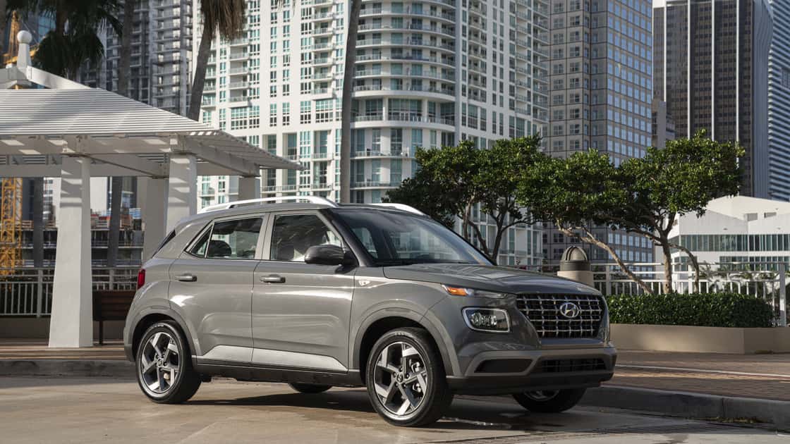 2026 Hyundai Venue gray exterior parked in urban environment showing front grille, headlights, side profile, and alloy wheels.