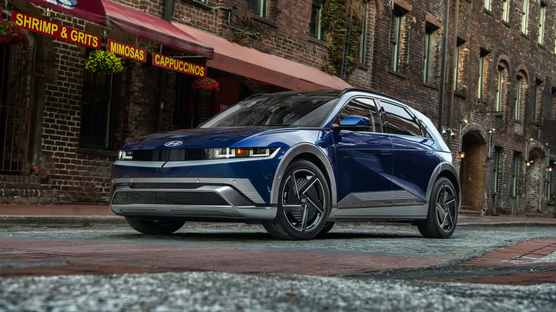 2026 Hyundai IONIQ 5 blue electric SUV parked on a city street with pixel-style lighting and modern exterior design.
