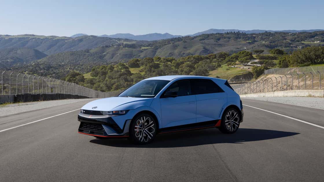 2026 Hyundai IONIQ 5 N in blue parked on a track with performance styling, red accents, and mountain views.