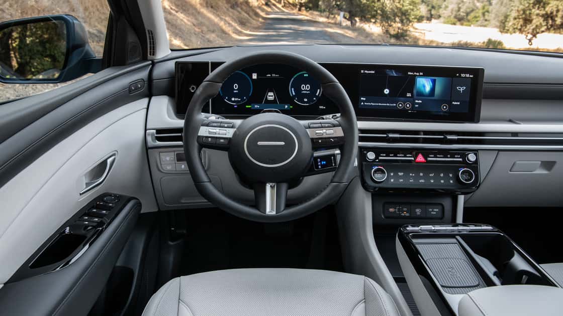 2026 Hyundai Tucson Hybrid interior with digital driver display, wide touchscreen, and two-tone cabin design.