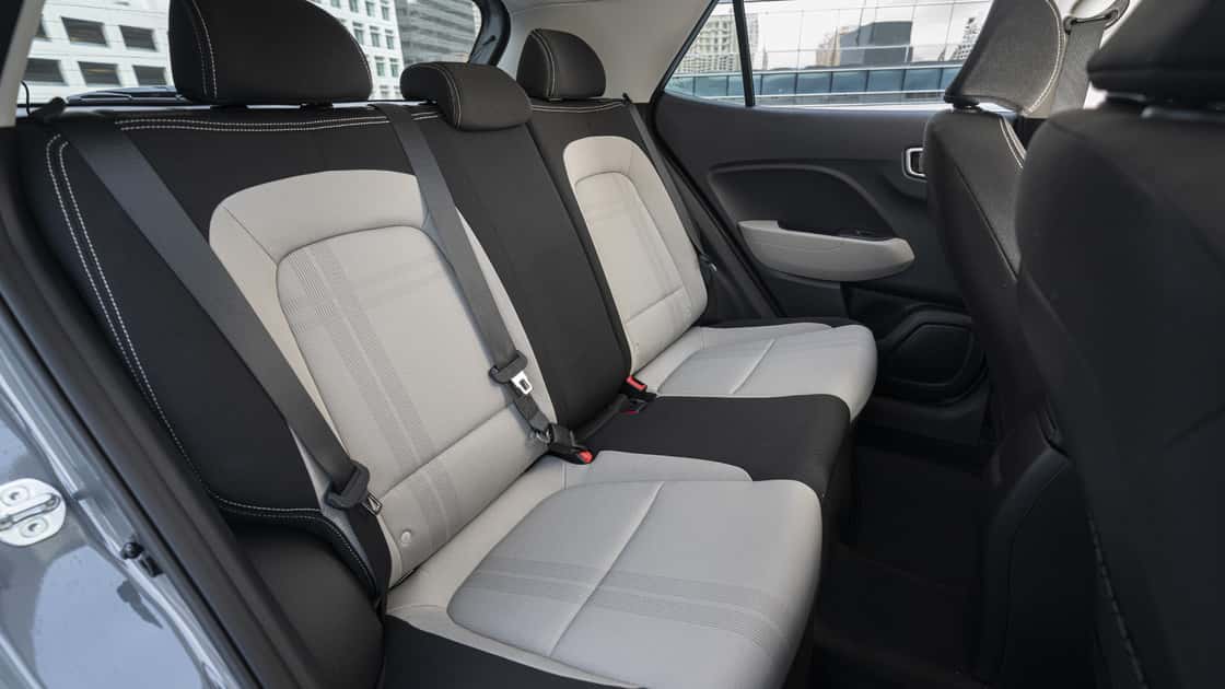 2026 Hyundai Venue rear seats with two-tone cloth upholstery, seatbelts, and compact passenger space.