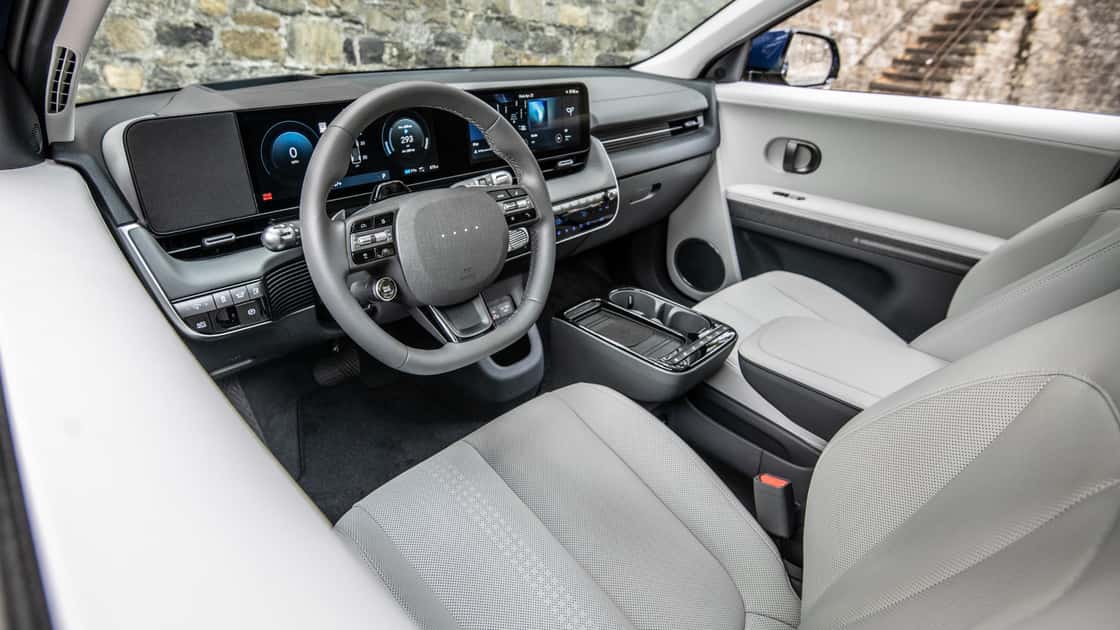 2026 Hyundai Kona interior with light gray seats, digital driver display, touchscreen, and modern dashboard controls.
