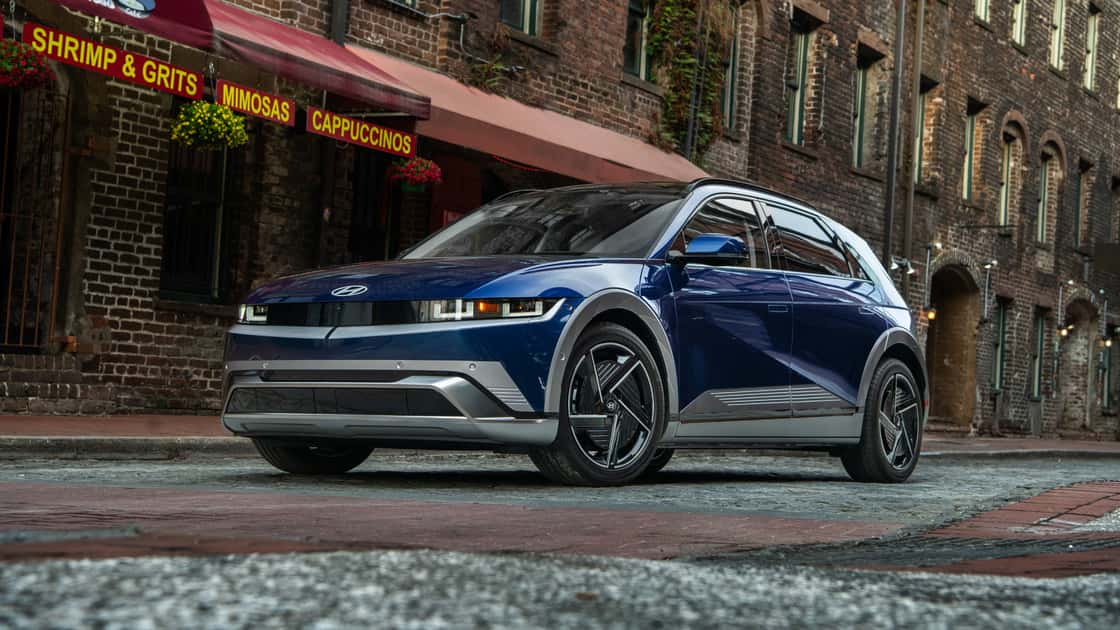 2026 Hyundai Kona driving on a highway with gray exterior, sharp body lines, and compact SUV design.
