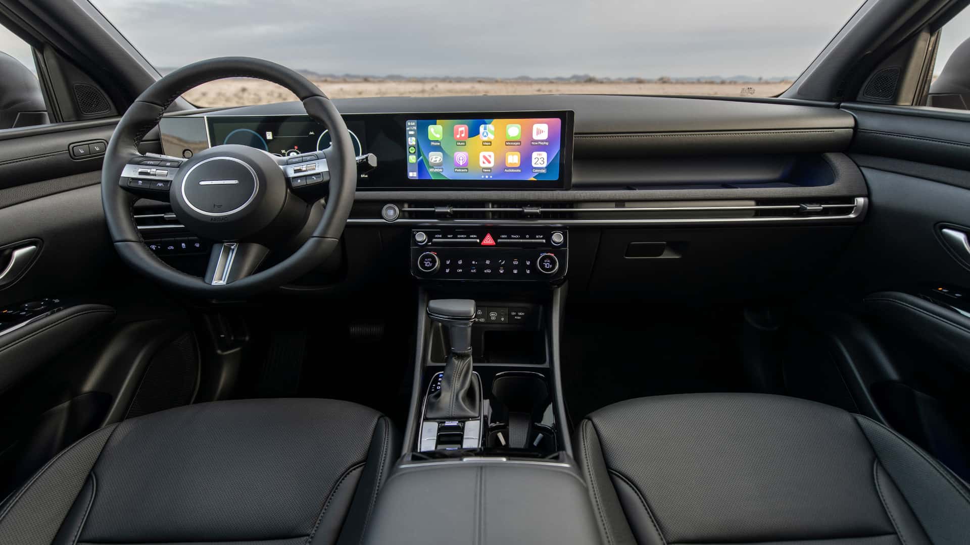 2026 Hyundai Santa Cruz front seats with black upholstery, touchscreen display, and open driver-focused cabin design.