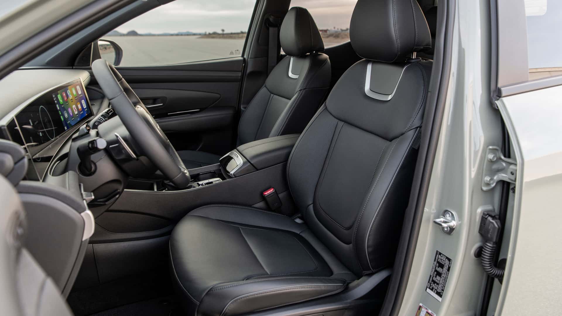 2026 Hyundai Santa Cruz interior with wide digital display, black cabin trim, climate controls, and modern dashboard layout.