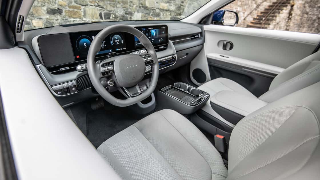 2027 Hyundai IONIQ 5 front seats with light gray upholstery, panoramic roof, and clean cabin layout.