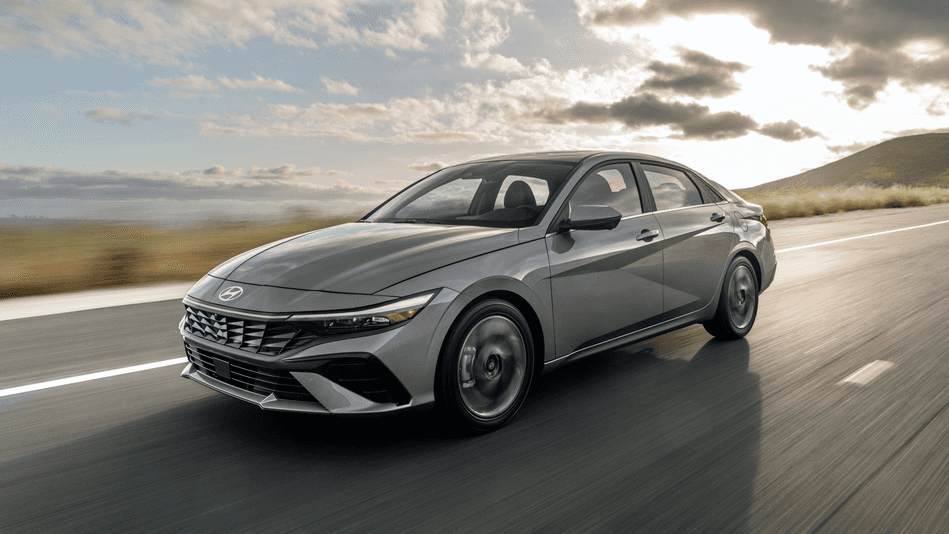 The 2025 Hyundai Elantra sedan cruising on a scenic highway under a partly cloudy sky.
