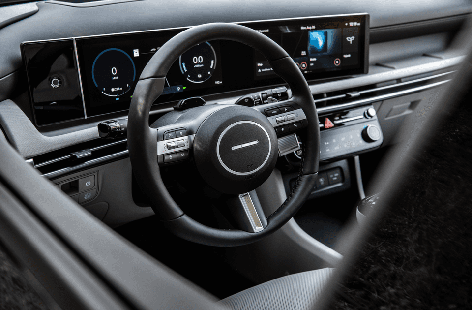 Close-up of the 2025 Tucson Hybrid cockpit showing the steering wheel and digital gauge cluster.