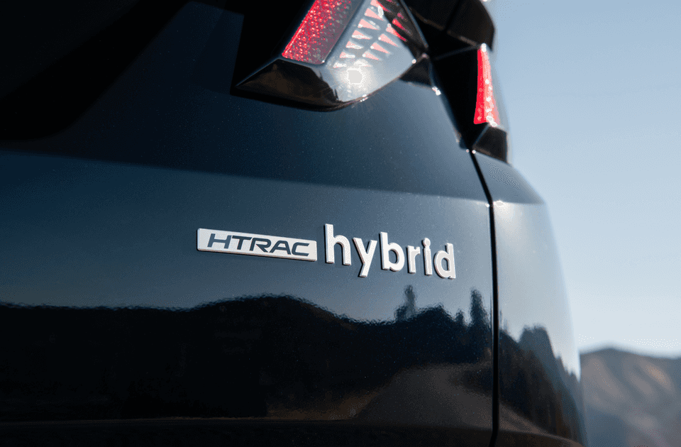 HTRAC hybrid badge on the rear of a 2025 Hyundai Tucson Hybrid with taillight partially visible.