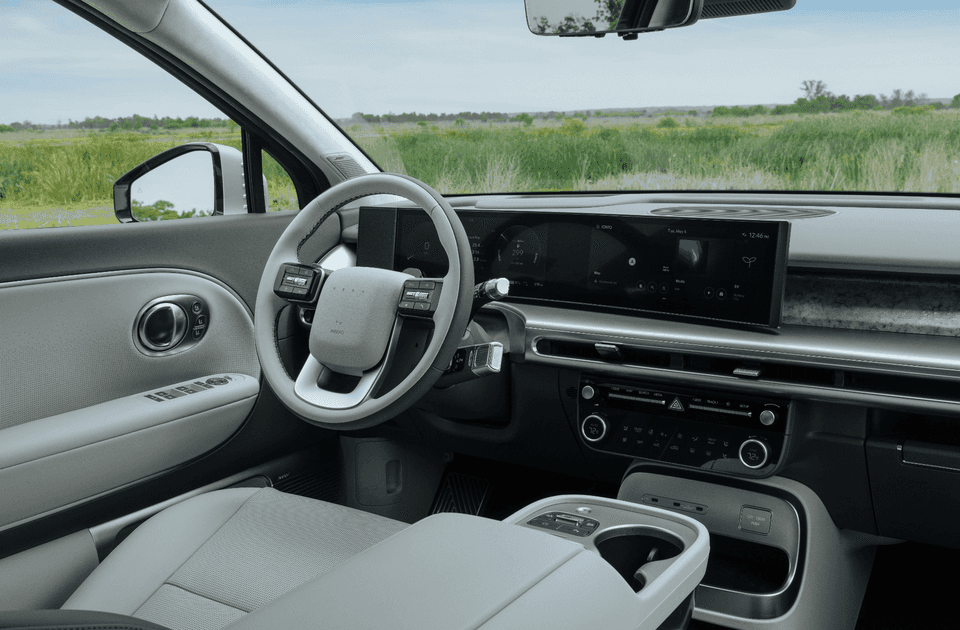 Front interior of 2026 Hyundai IONIQ 9 showcasing steering wheel, infotainment screen, and modern dashboard.