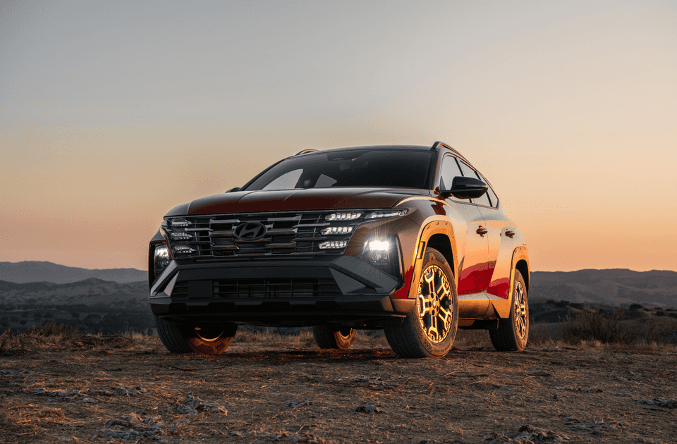 Front view of 2025 Hyundai Tucson in the desert with signature LED lights and wide grille.