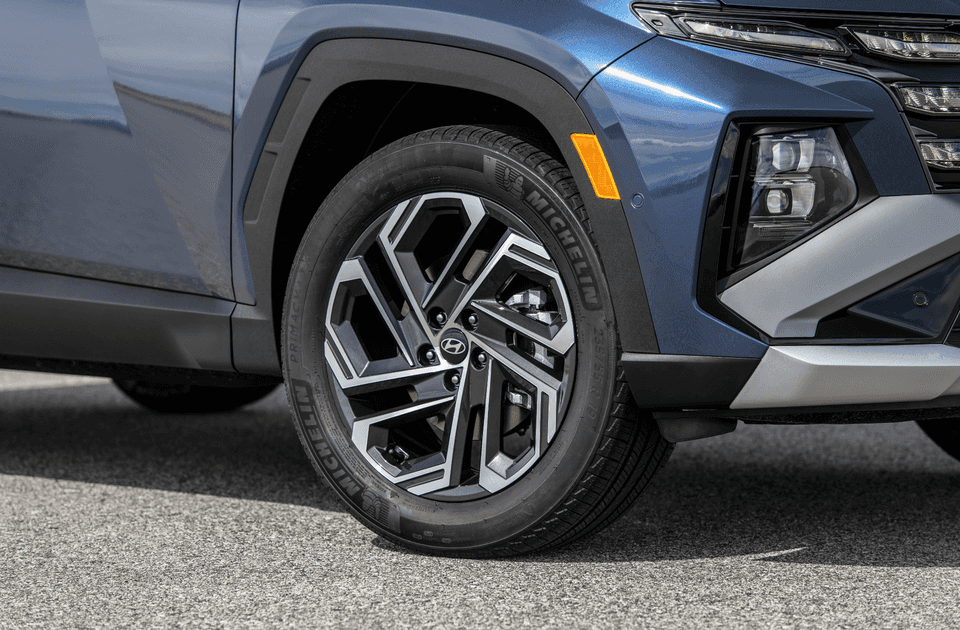 Close-up of 2025 Hyundai Tucson front wheel with geometric alloy design and Michelin tire.