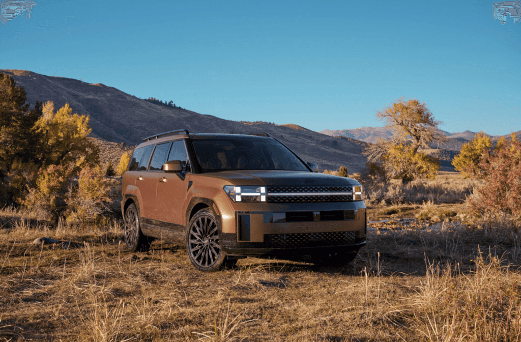 2026 Hyundai Santa Fe Hybrid in bronze metallic parked in a scenic mountain landscape.