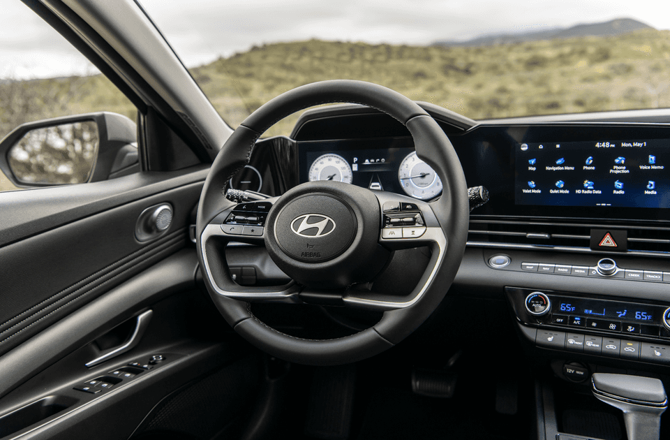 2025 Hyundai Elantra interior view with steering wheel and digital display screen.