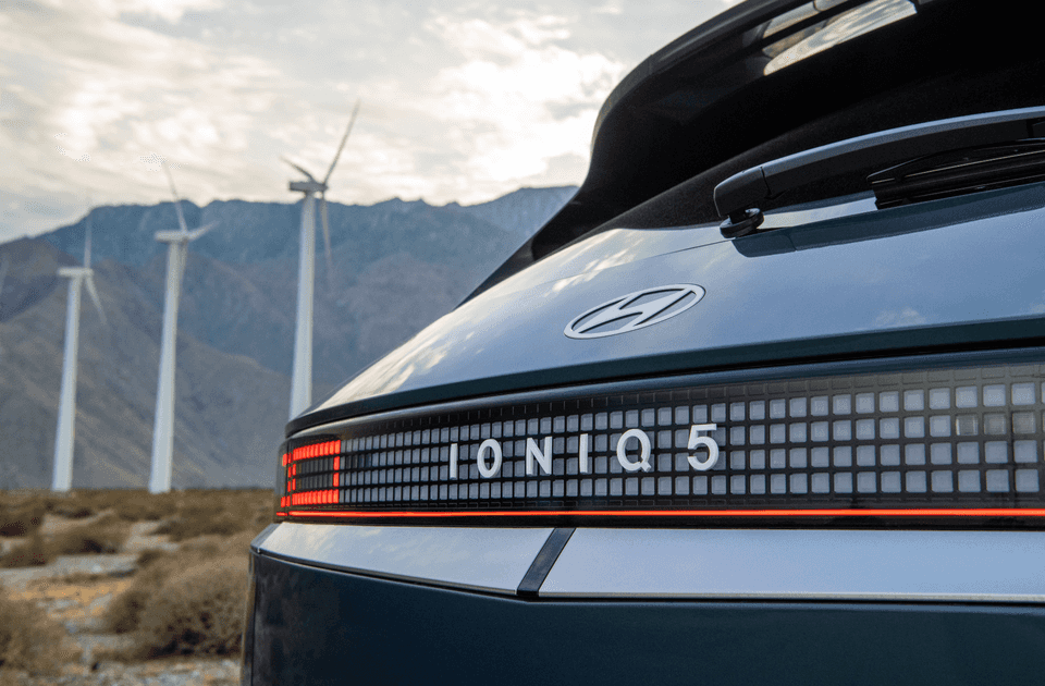 2025 Hyundai IONIQ 5 rear view with pixel tail lights and model badge near wind turbines.