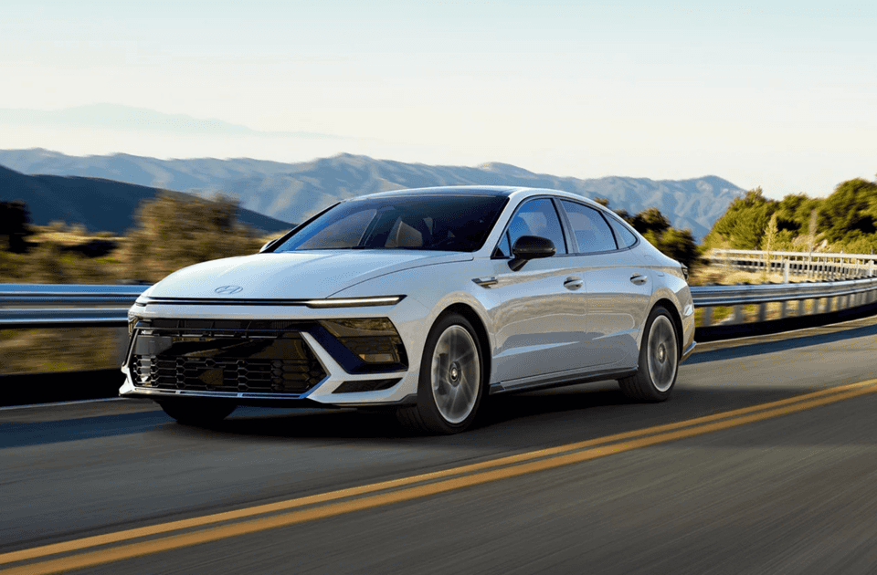2025 Hyundai Sonata sedan driving on road with modern headlights and bold front fascia.