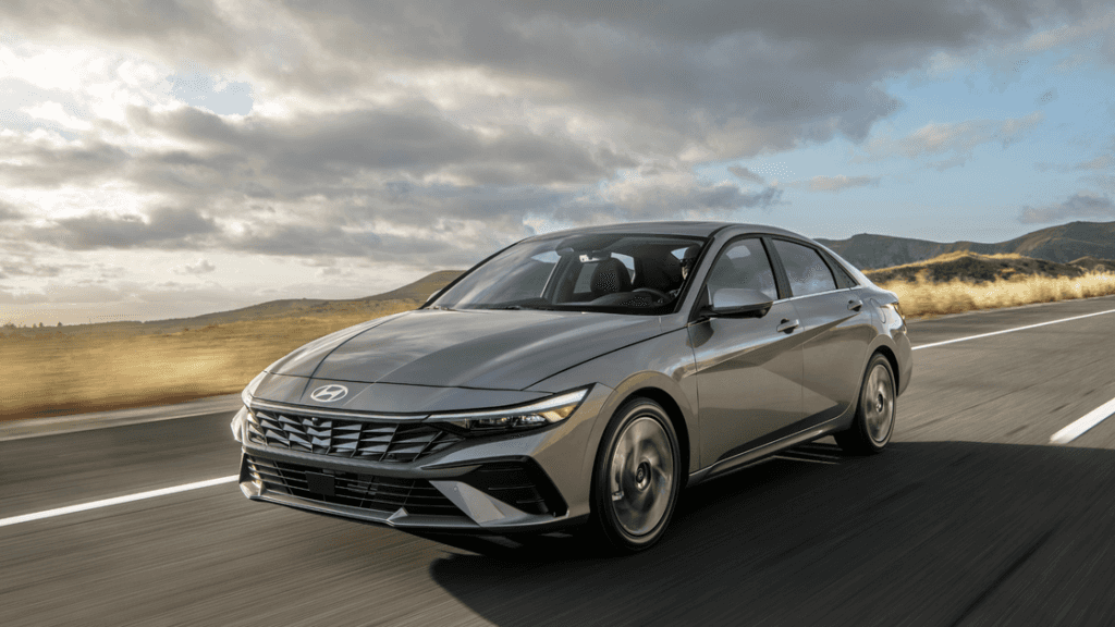 2026 Hyundai Elantra sedan driving on open highway with sleek modern design and gray exterior.