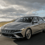 2026 Hyundai Elantra sedan driving on open highway with sleek modern design and gray exterior.