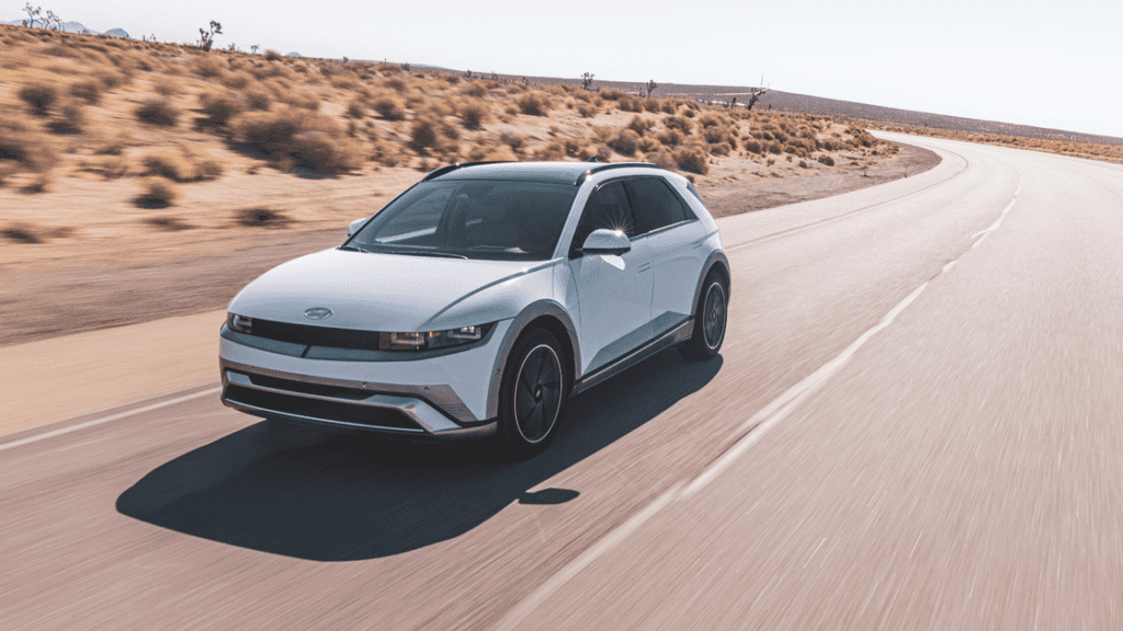 2026 Hyundai IONIQ 5 electric SUV in white driving through desert road with futuristic styling.