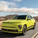 Yellow 2026 Hyundai Kona Electric cruising on open road highlighting modern EV design.