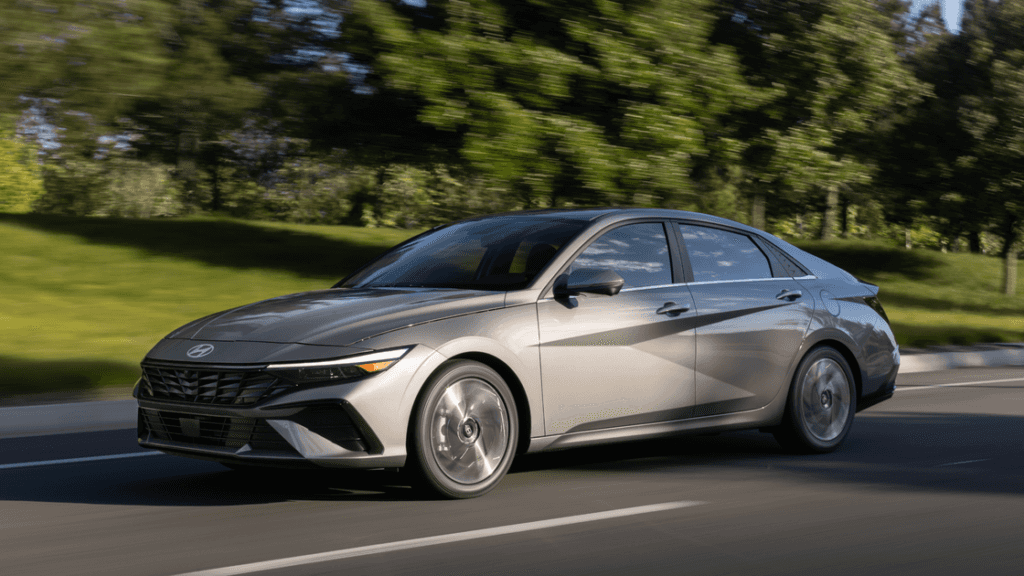 2026 Hyundai Elantra in motion on a suburban road highlighting its sleek exterior and modern profile..