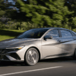 2026 Hyundai Elantra in motion on a suburban road highlighting its sleek exterior and modern profile..