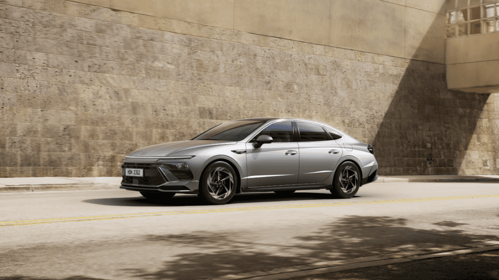 2026 Hyundai Sonata cruising through the city with its sharp body lines and upscale aerodynamic styling.