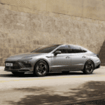 2026 Hyundai Sonata cruising through the city with its sharp body lines and upscale aerodynamic styling.