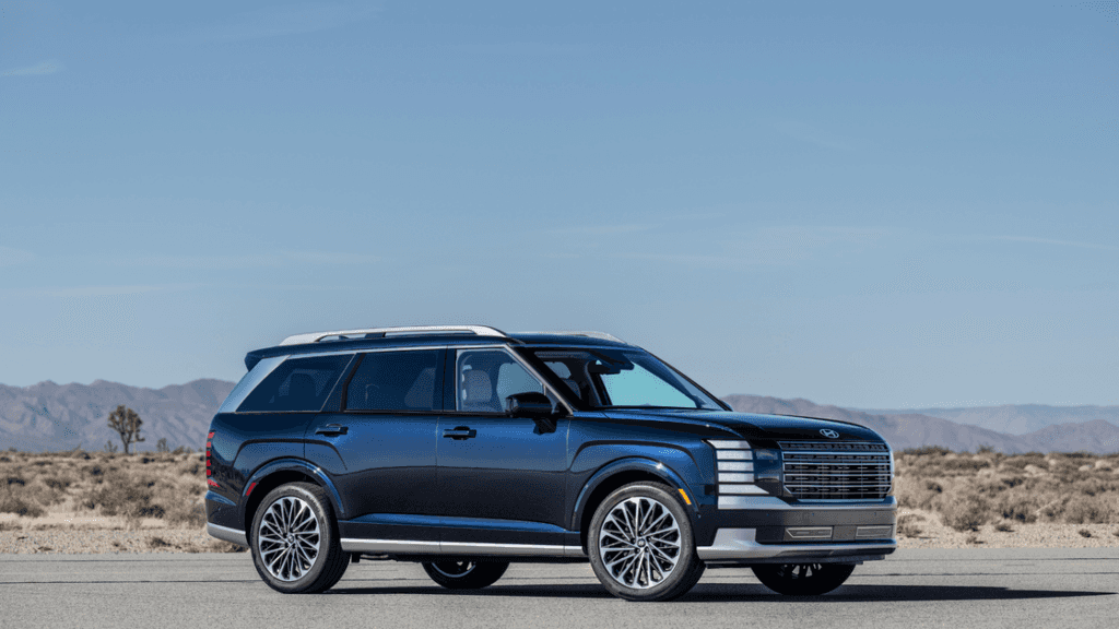 2026 Hyundai Palisade SUV shown in blue exterior, side profile on desert road with alloy wheels.