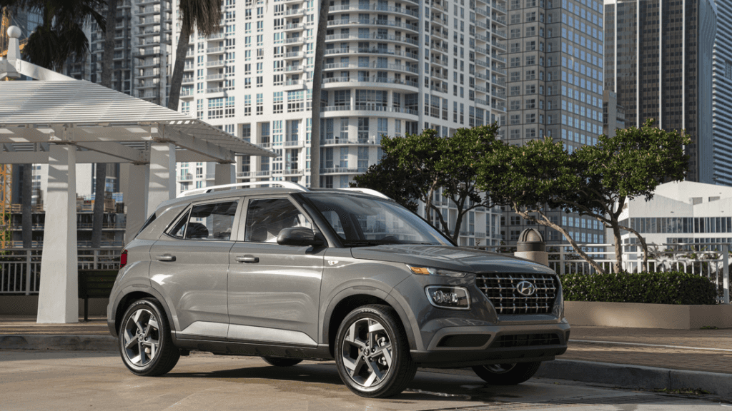 2026 Hyundai Venue subcompact SUV parked in urban setting, silver exterior with city backdrop.