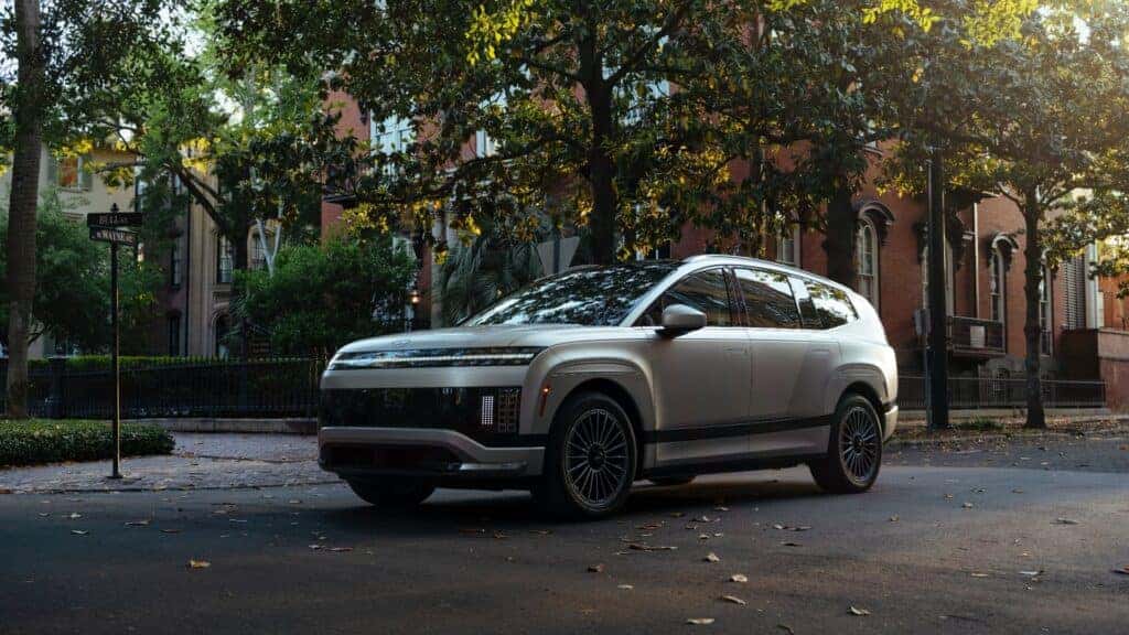 2026 Hyundai IONIQ 9 electric SUV parked on a tree-lined residential street showcasing modern exterior design.