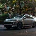 2026 Hyundai IONIQ 9 electric SUV parked on a tree-lined city street, showcasing modern exterior design and premium wheels.