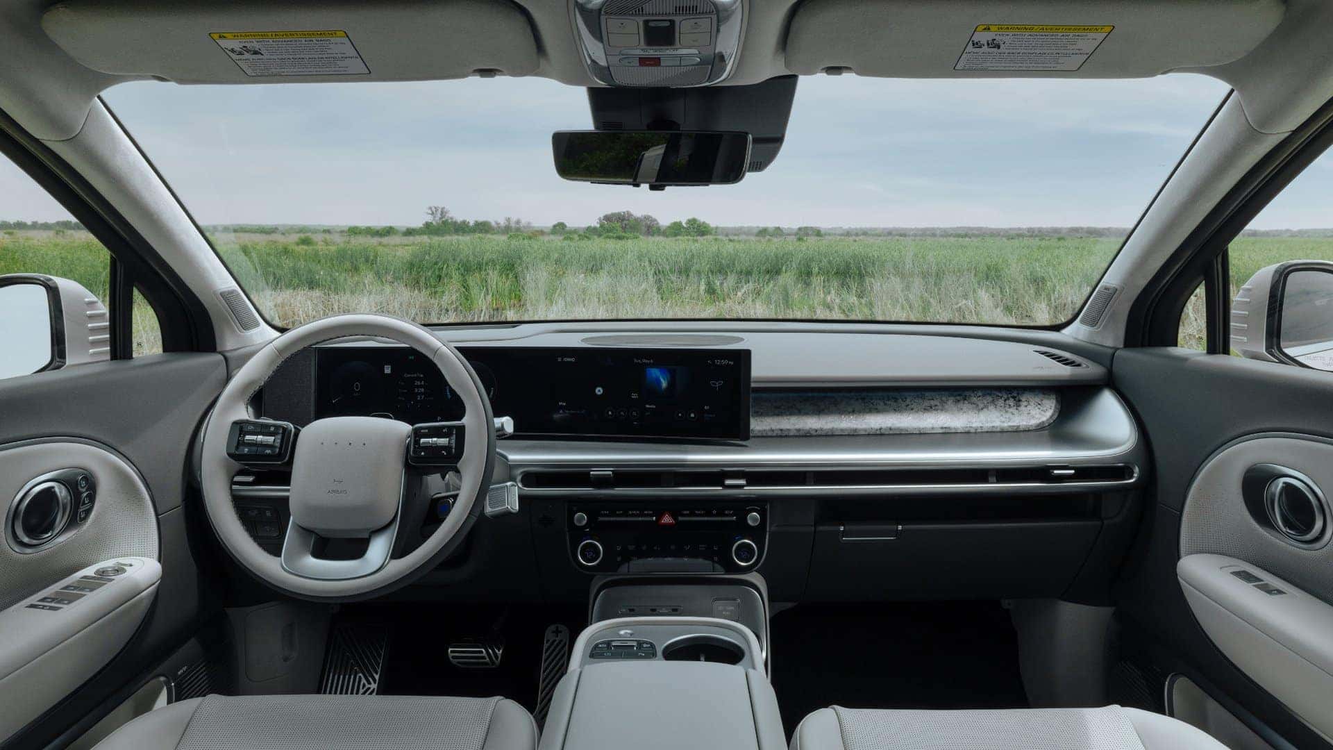 2026 Hyundai IONIQ 9 interior dashboard view with digital displays, steering wheel controls, and panoramic windshield.